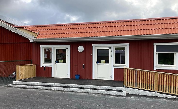 Röd träbyggnad, två dörrar.